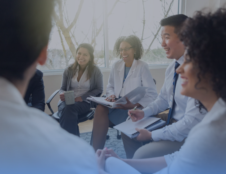 A diverse group of healthcare and business professionals in discussion, highlighting collaboration, inclusivity, and teamwork in healthcare strategy.